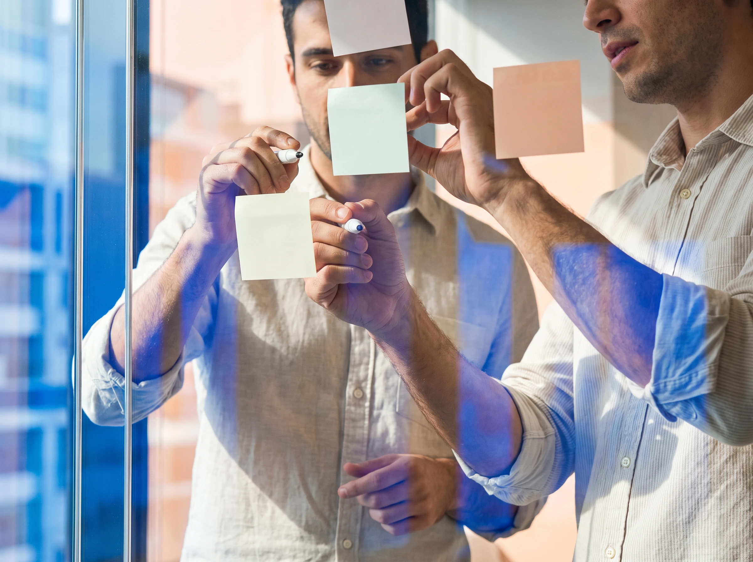 Colleagues mapping ideas on a glass wall